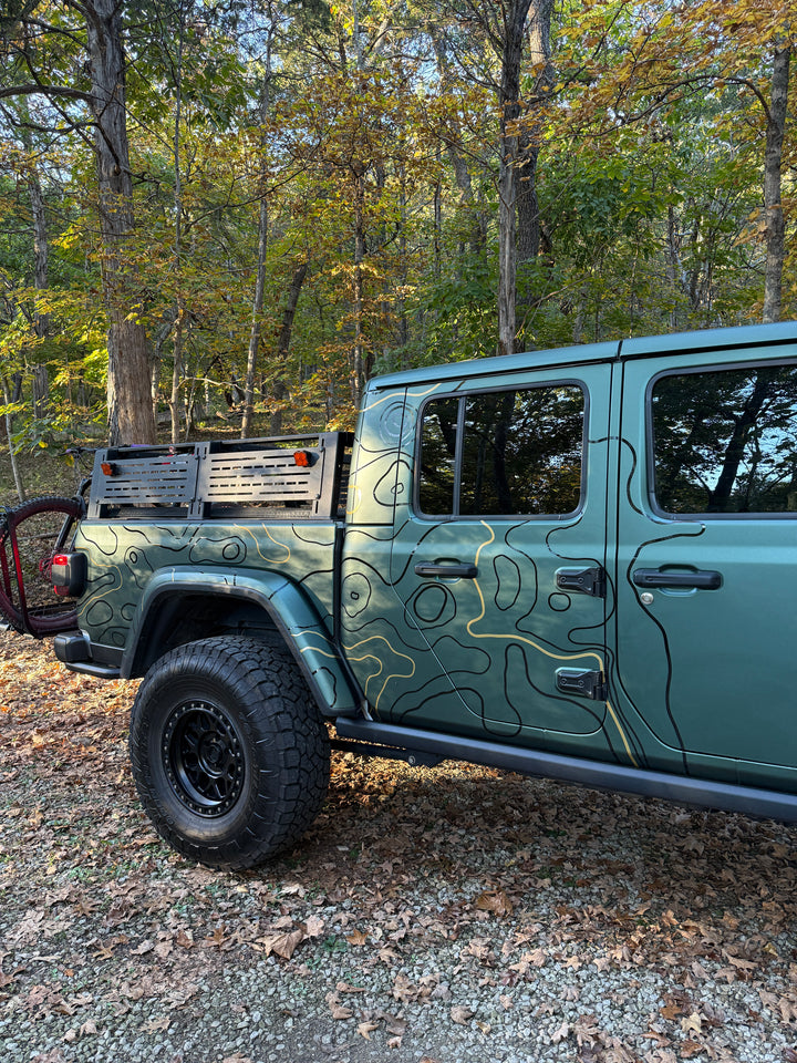 Rear three-quarter view of black and metallic gold topo lines on a green truck