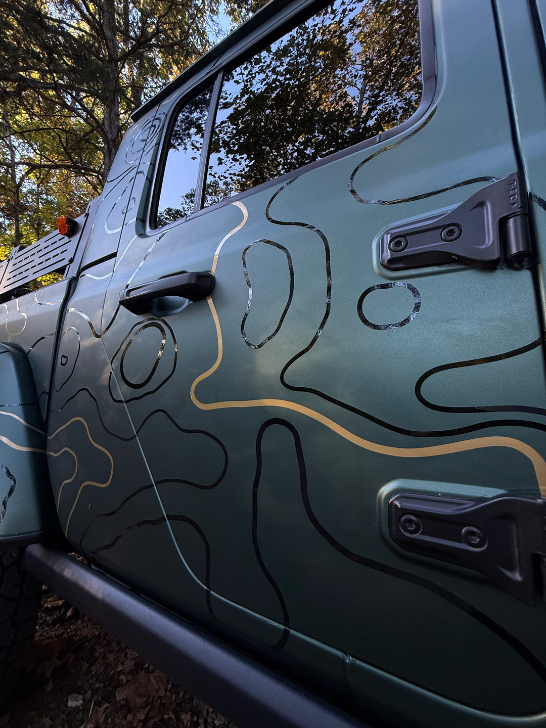 Low-angle close-up of topo lines flowing across the rear door